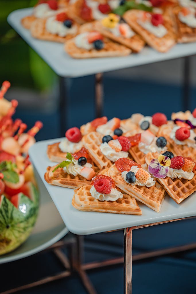Delicious waffles topped with fresh fruits and cream, perfect for a gourmet breakfast setting.